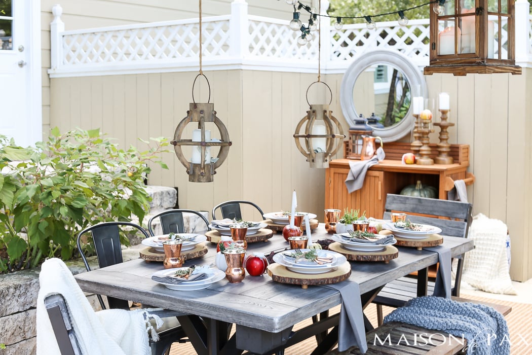 outdoor fall tablescape: lanterns, string lights, apple candles, and other cozy outdoor fall decorating ideas!