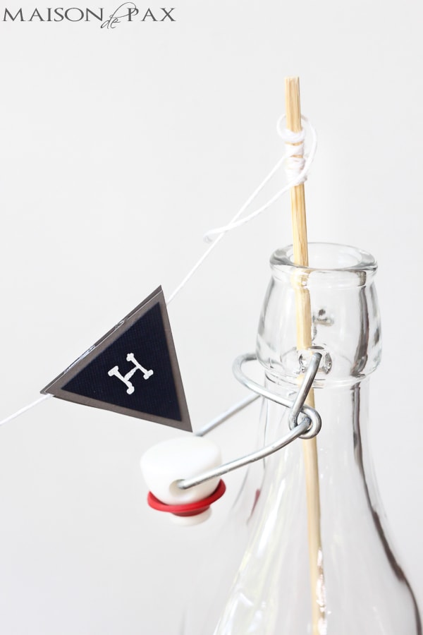 embroidery thread holds cardstock bunting to stick for party centerpiece | Maison de Pax