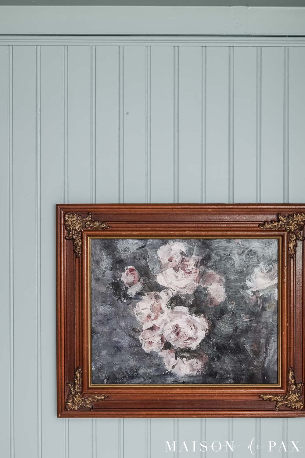 vintage frame with floral art hung on bead board wall