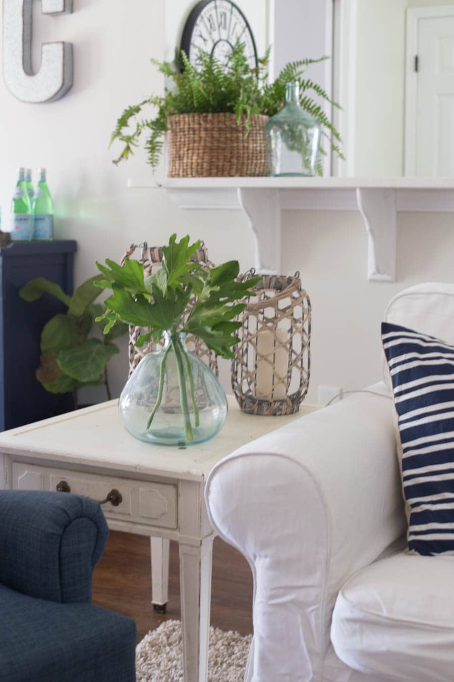 What a fun beachy vibe in this coastal living room! Blues, greens, weathered wood, and DIY wall art make it a beautiful, comfortable space.