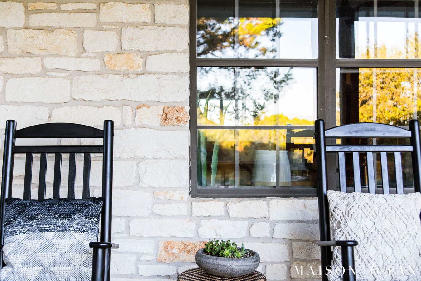 austin stone exterior with black windows and black rocking chairs on the porch | Maison de Pax