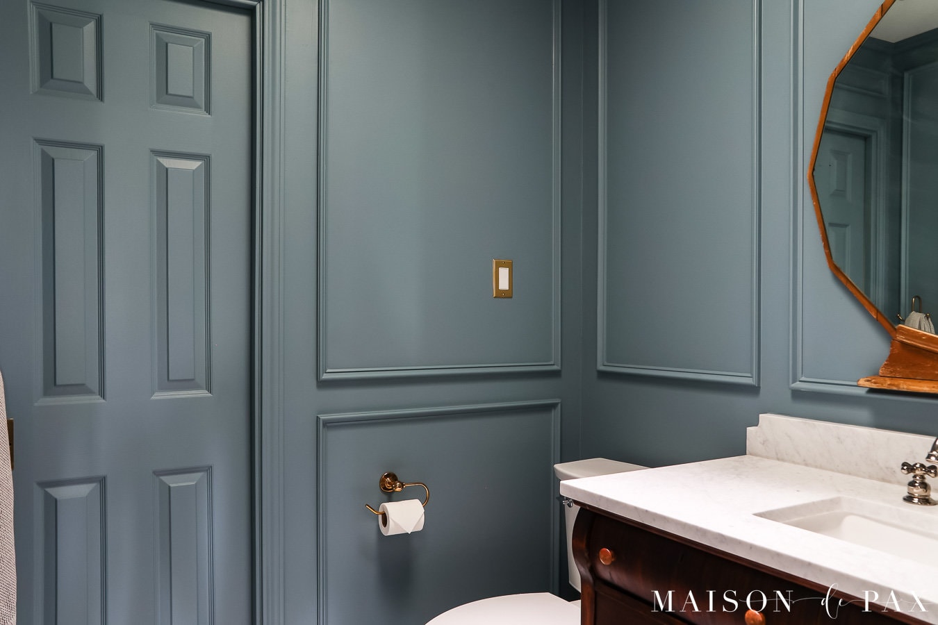 diy picture frame molding in a small moody blue bathroom