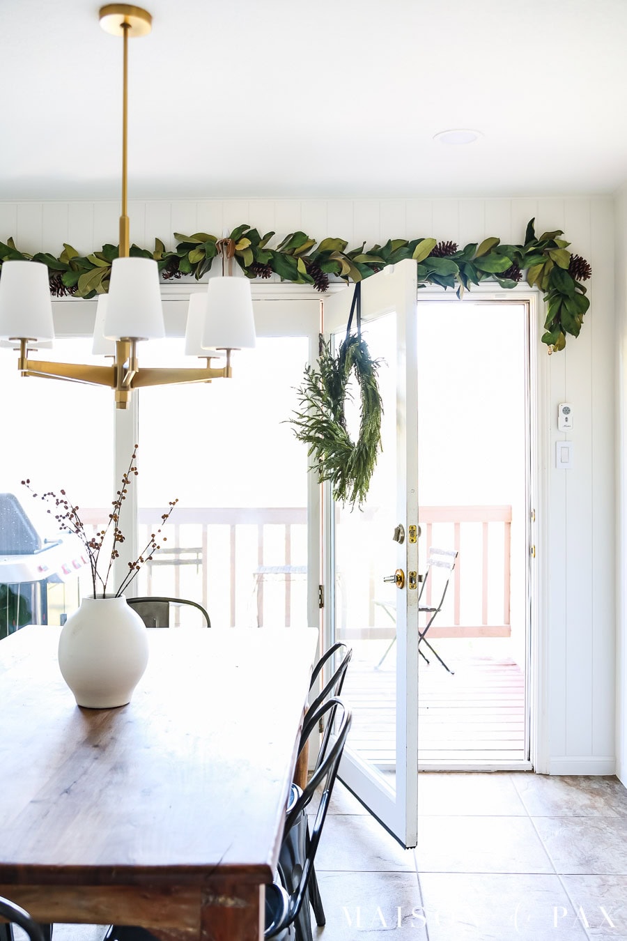 wreath hung from wood door using ribbon and a thumbtack