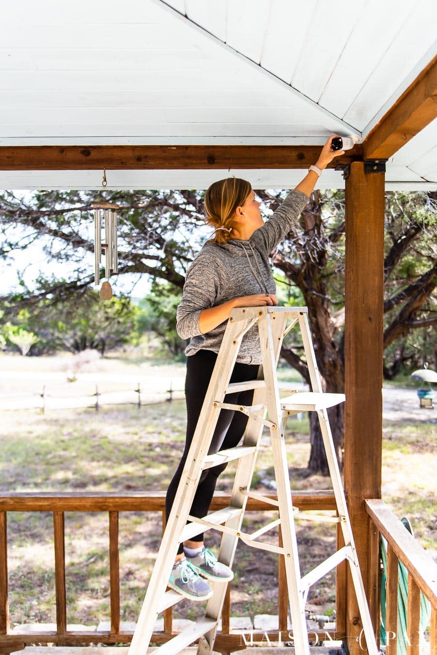 woman adjusting outdoor security camera | Maison de Pax