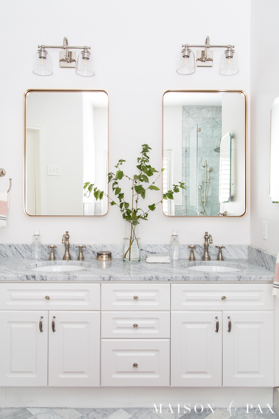 bath with marble counters, white vanity, polished nickel faucets, and gold mirrors | Maison de Pax
