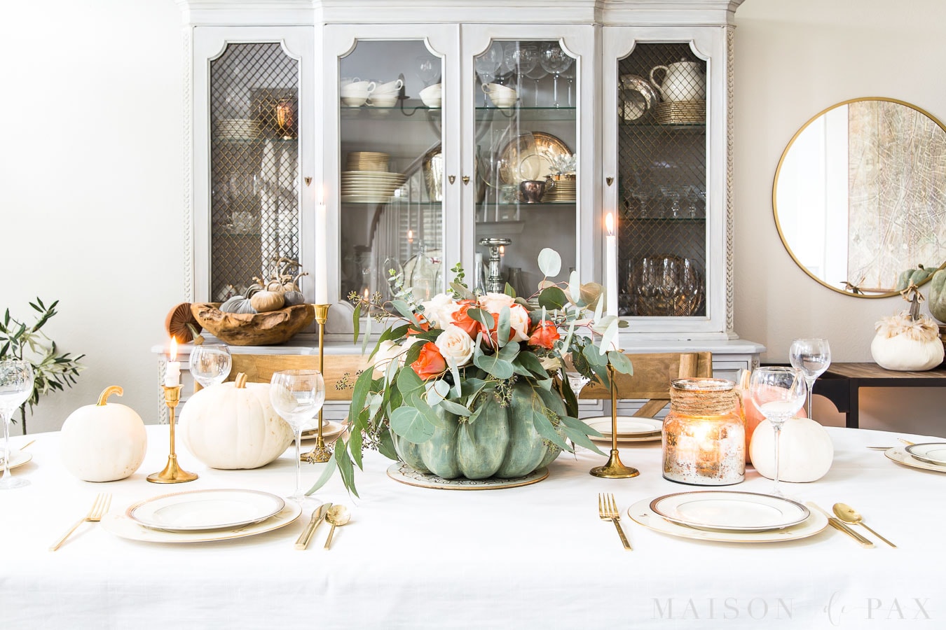 wide image of a Thanksgiving table with pumpkin floral centerpiece