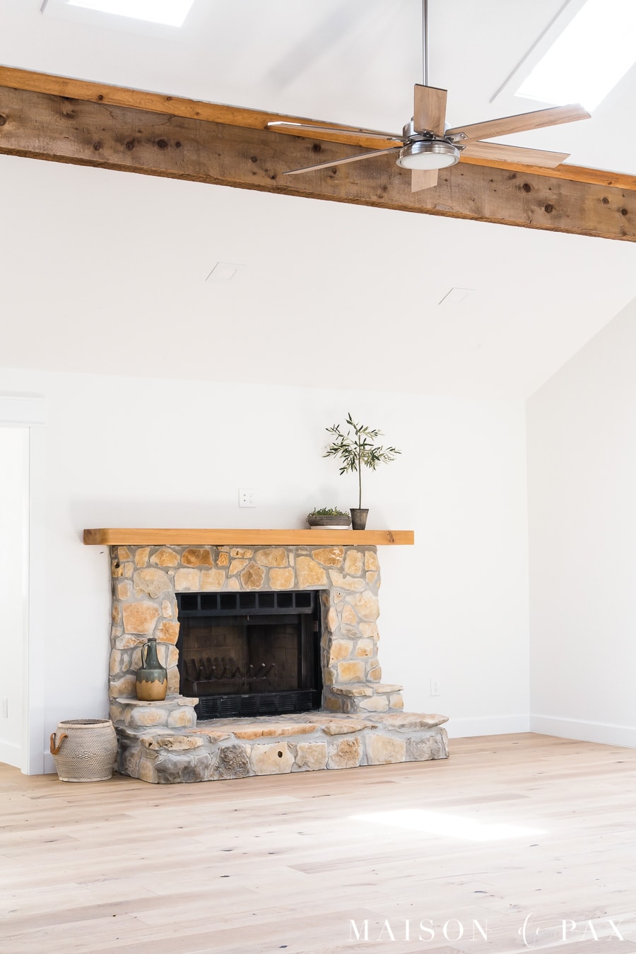 great room with ceiling fan and exposed beams