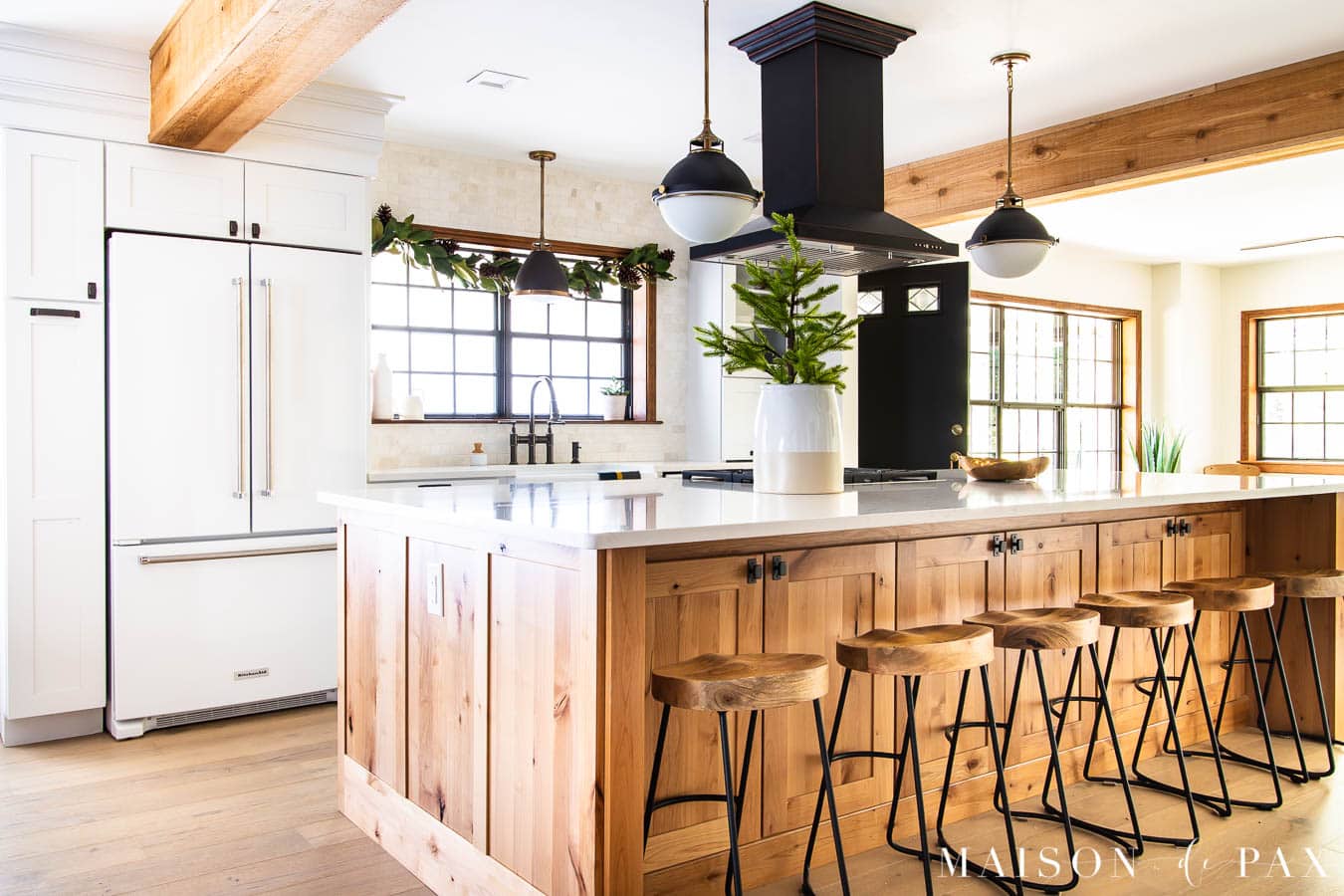 white kitchen with large wood island and holiday greenery | Maison de Pax
