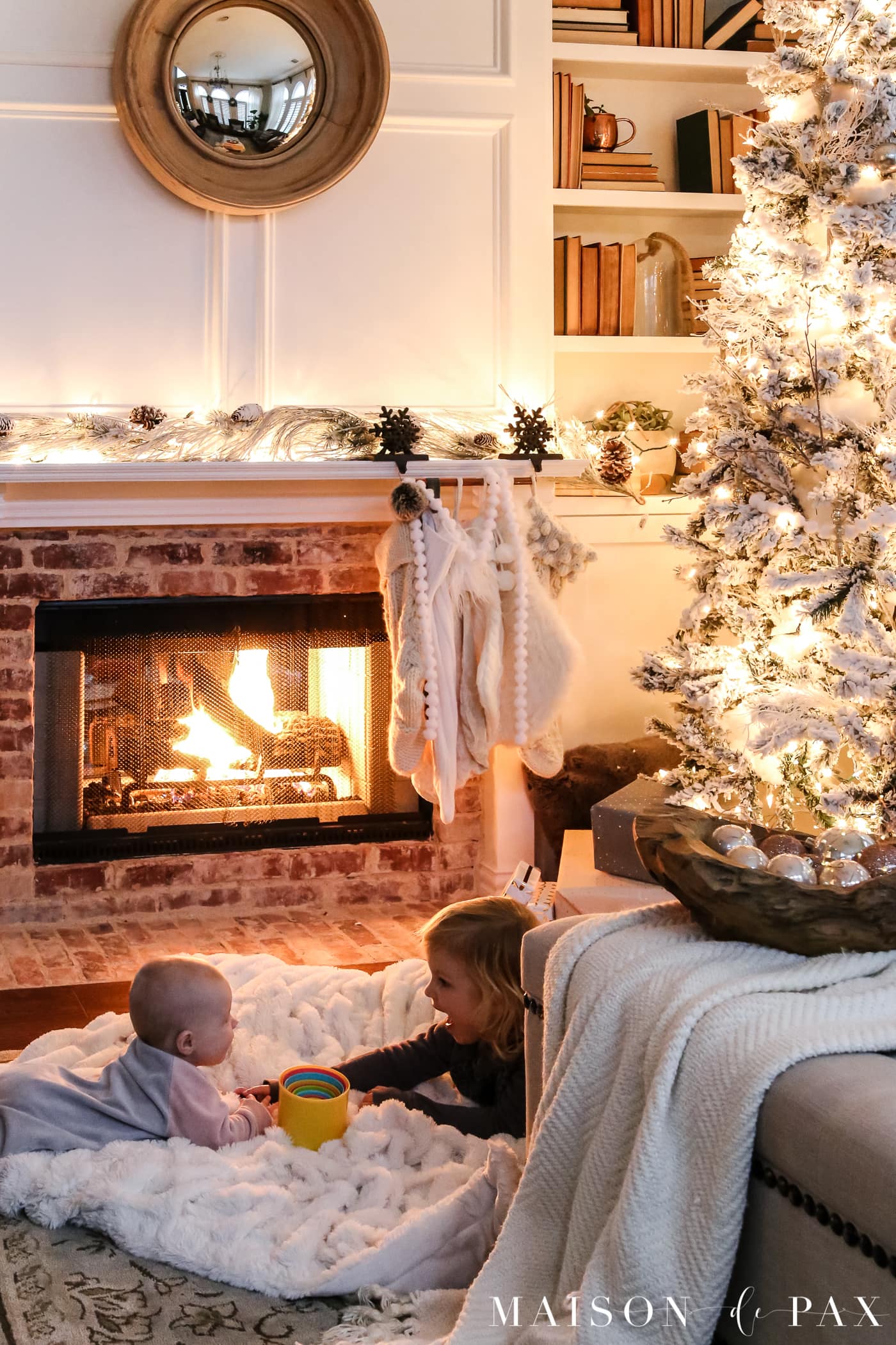 sweet little girls beside the fireplace: gorgeous Christmas lights at night in these 25+ home tours #christmasnightstour #holidayhometour #christmaslights