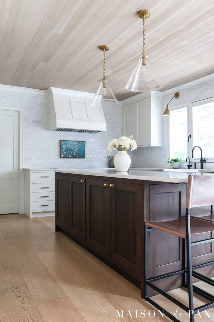 white kitchen with light wood floors and dark wood island