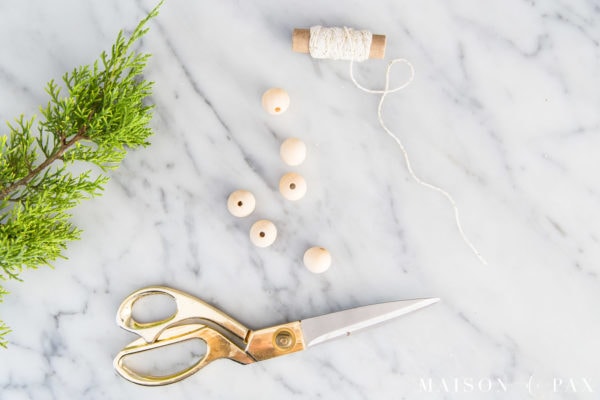 wood beads, scissors, twine, and cedar garland