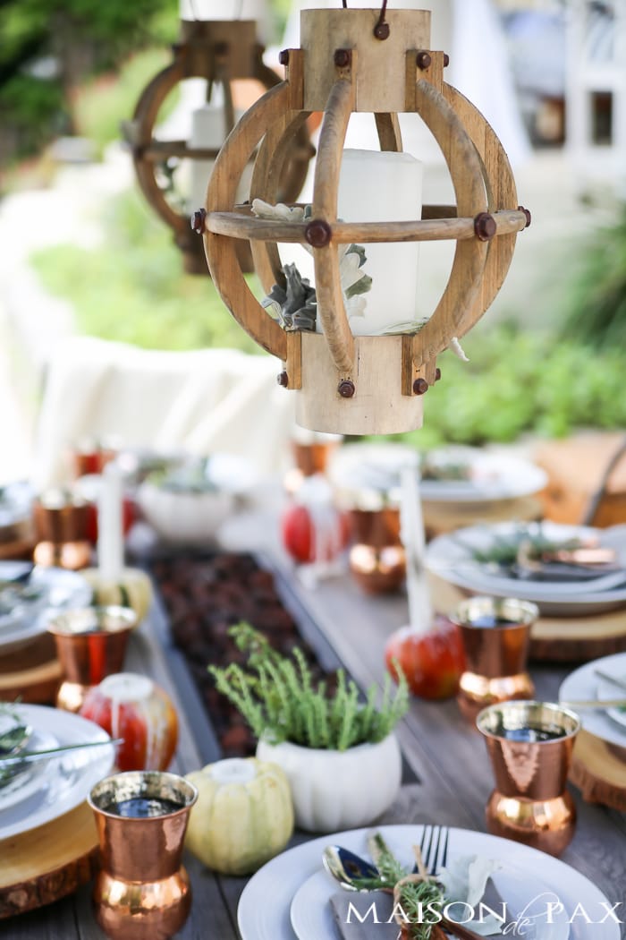 outdoor fall tablescape: lanterns, string lights, apple candles, and other cozy outdoor fall decorating ideas!