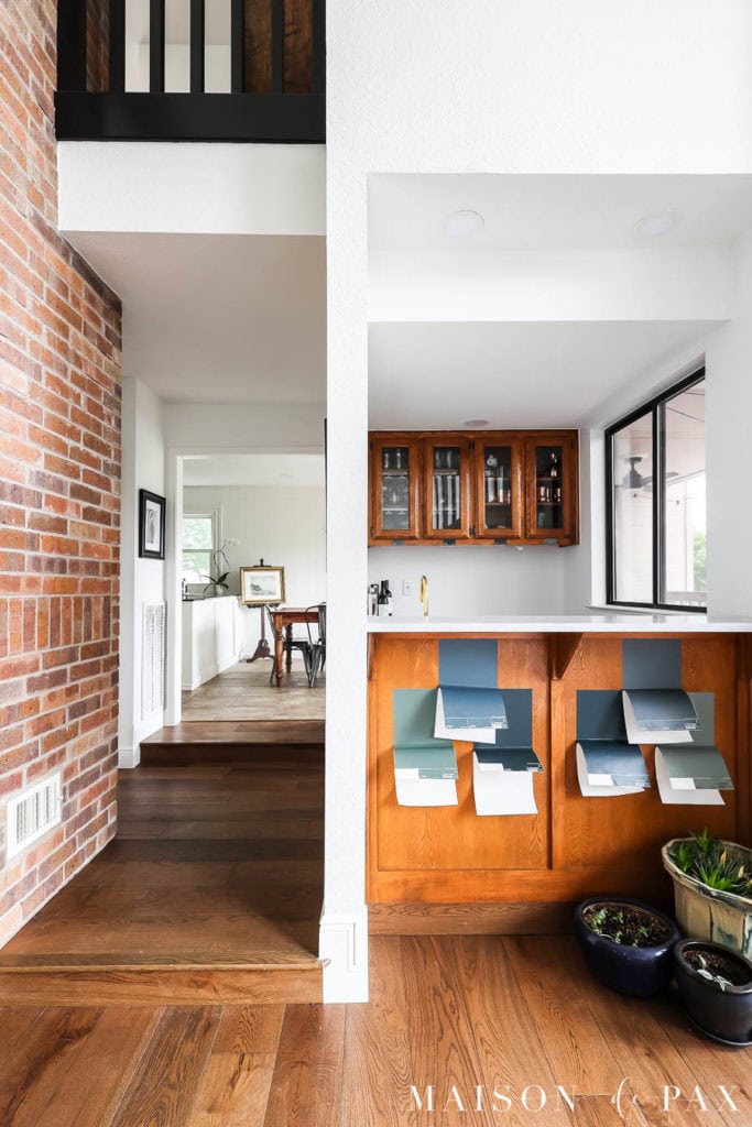 medium brown wood floors by orange oak cabinets with blue and green paint samples
