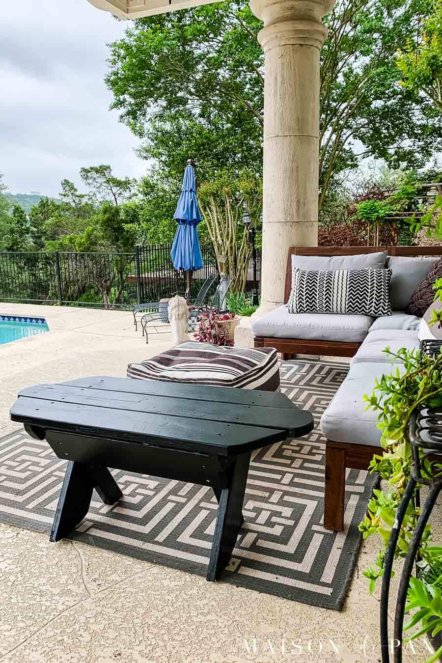 Black painted bench on patio