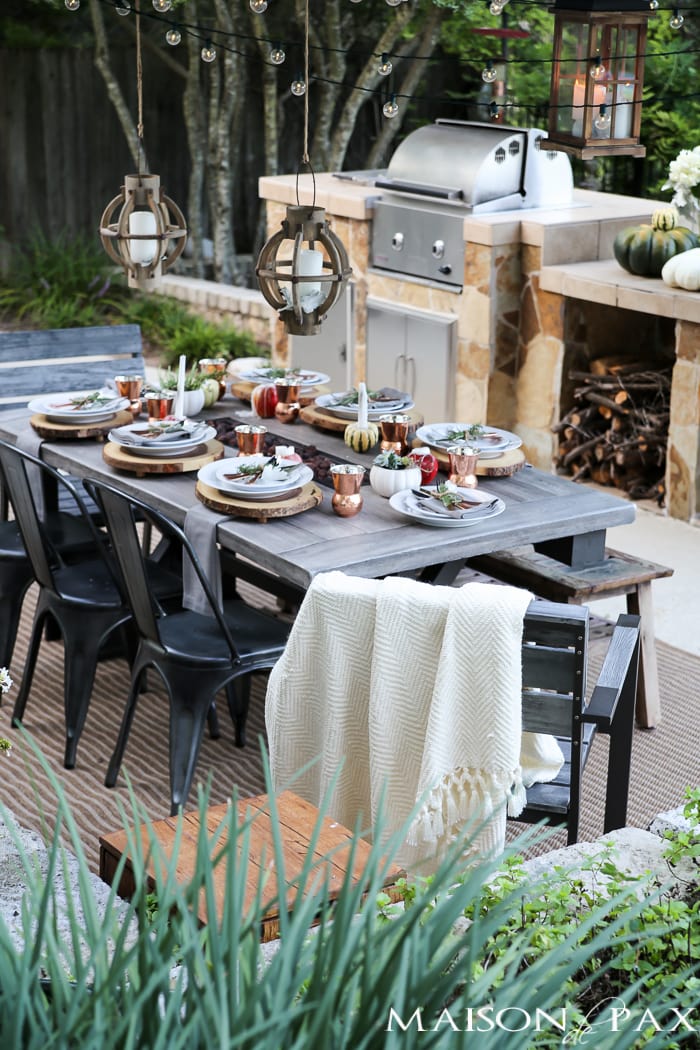 10 tips for a magical outdoor dining table: lanterns, string lights, apple candles, and other cozy outdoor fall decorating ideas!