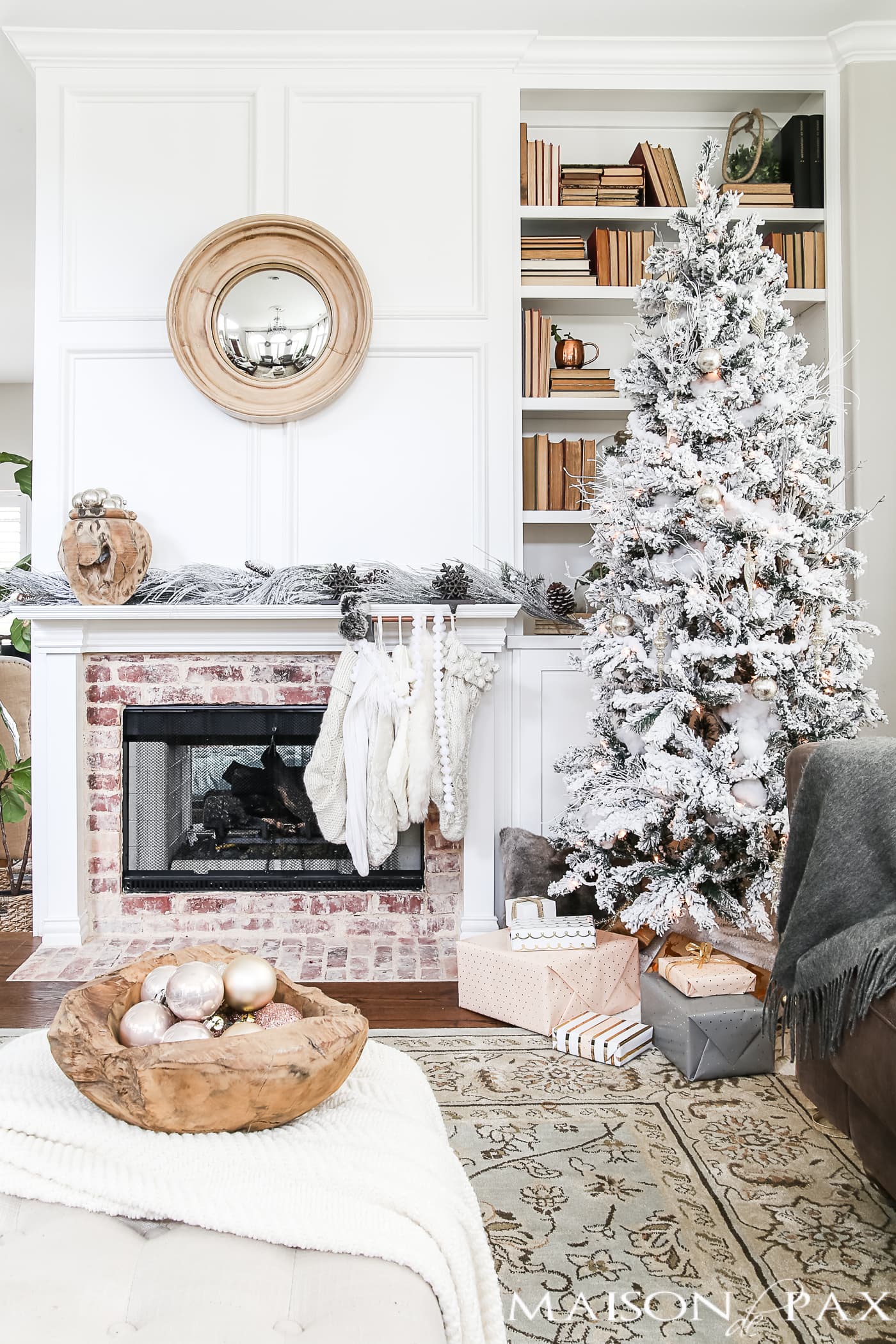 flocked tree with neutral decorations beside a mantel with cream and white stockings #neutralChristmasdecor