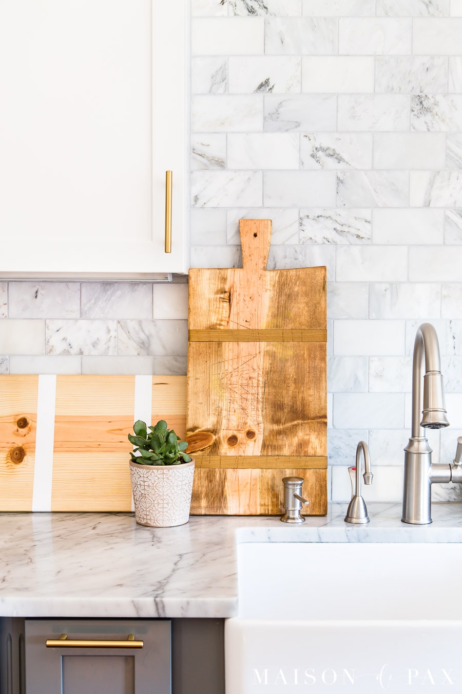 gorgeous antique french breadboards on display in marble kitchen | Maison de Pax