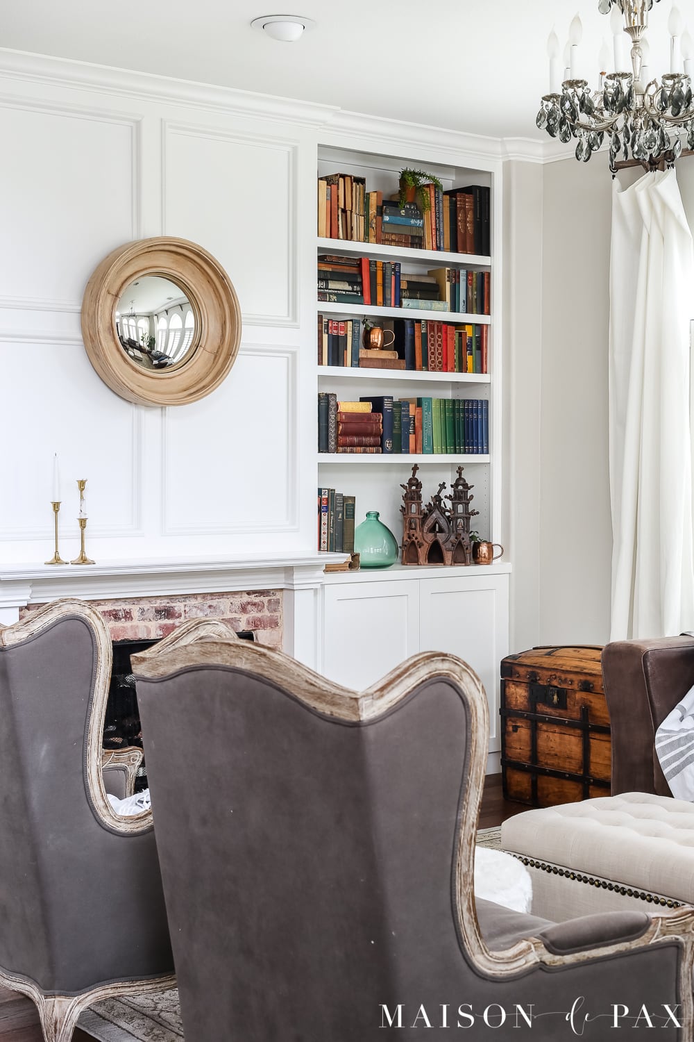 Love the white bookcases filled with colorful antique books. Wondering how to seasonally decorate your living spaces without going to too much trouble?  Get my best tips for transitioning from winter whites to neutrals, blues, and greens for a spring living room. #springdecor #springdecorating #springlivingroom #antiquebooks #howtodecorate #seasonaldecor #seasonaldecorating