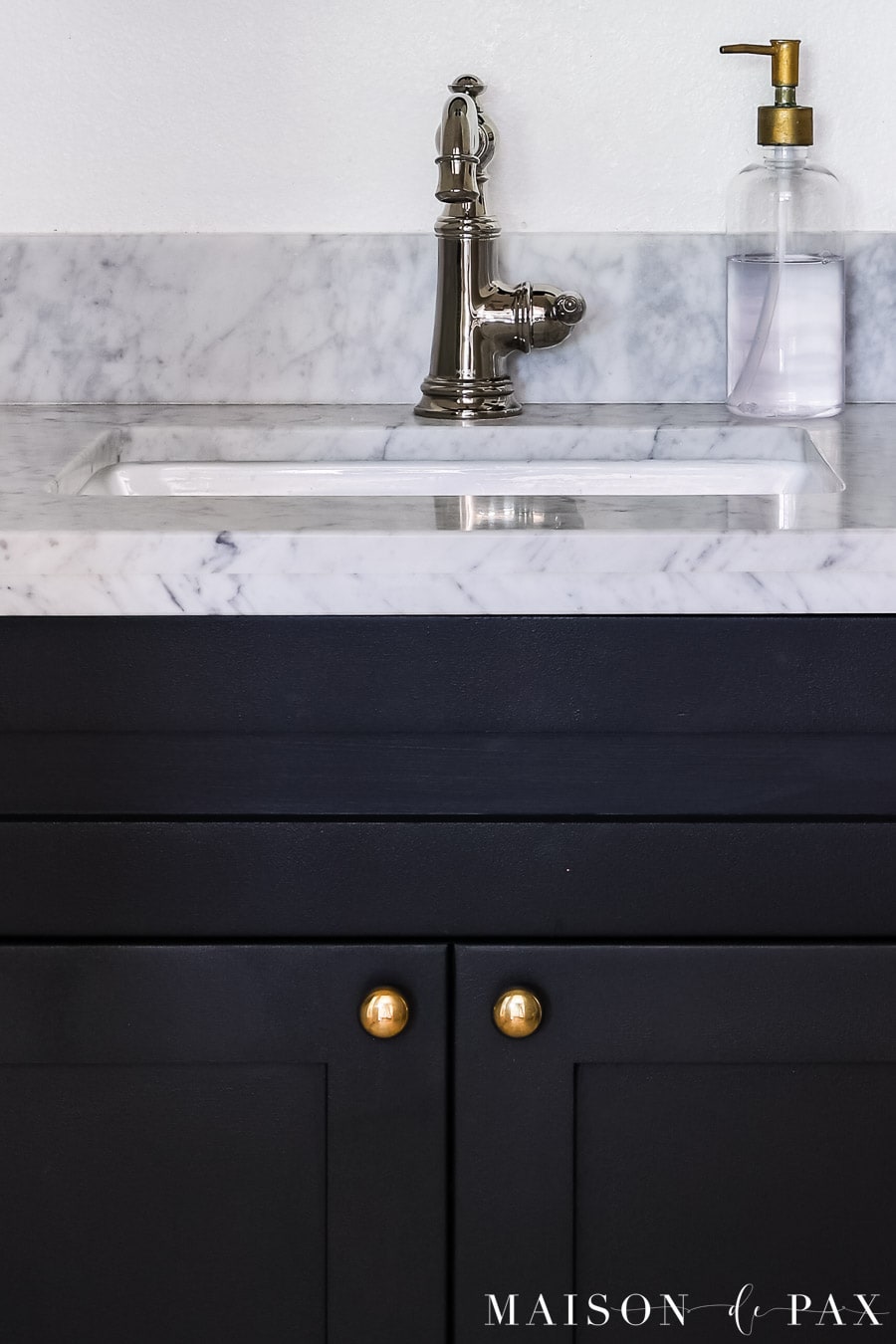 black cabinet with unlacquered brass knobs