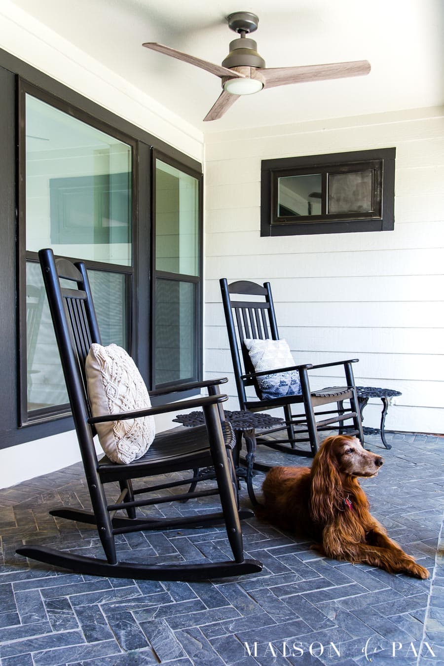 black and white porch with slate floors and outdoor ceiling fan