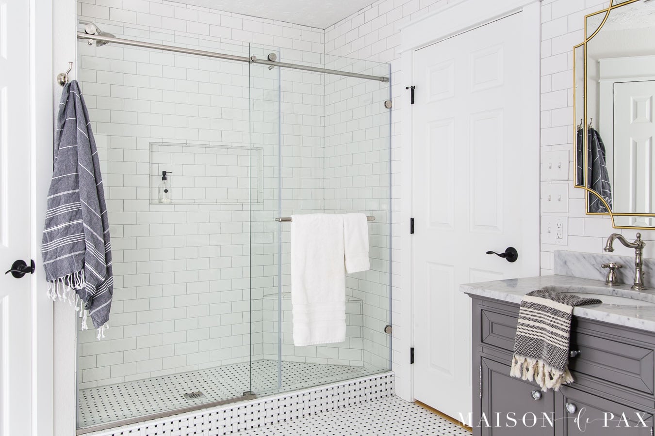 walk in shower with black and white basketweave tile floors