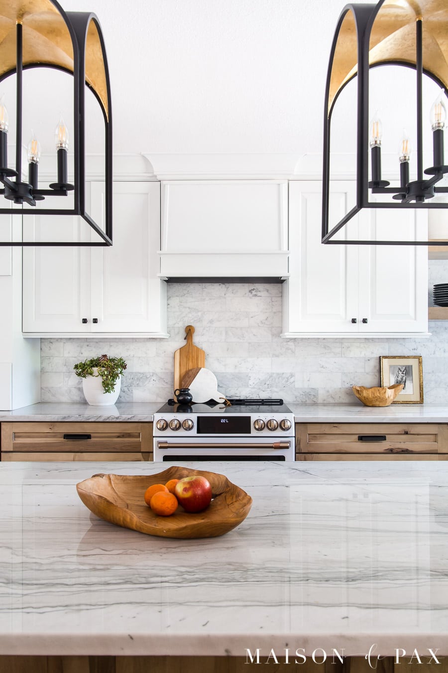 black and gold lanterns over kitchen island with quartzite countertops