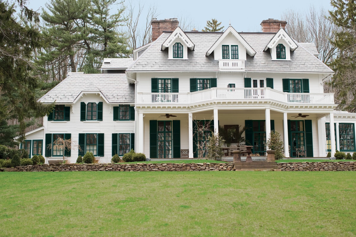 large white traditional home with black windows and black shutters | Maison de Pax