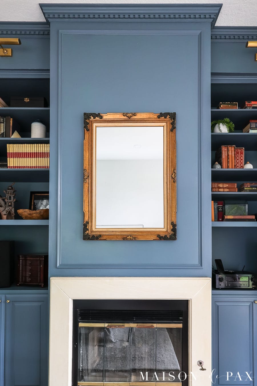 ornate gold antique mirror hung above limestone fireplace