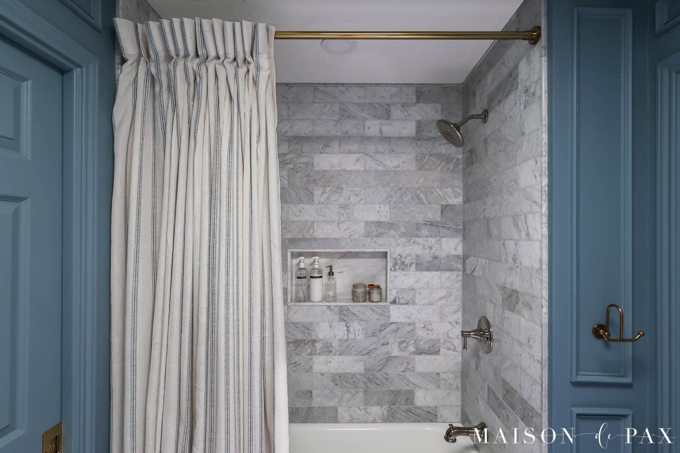 marble bathroom with pinch pleat drapes as shower curtain