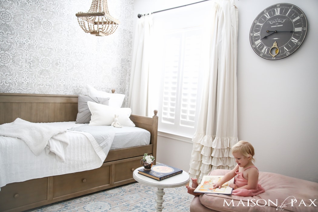 Elegant, neutral little girl room with wood tones and a stenciled accent wall: A gray-washed trundle bed provides the perfect anchor for a gorgeous, neutral yet feminine little girl's room.