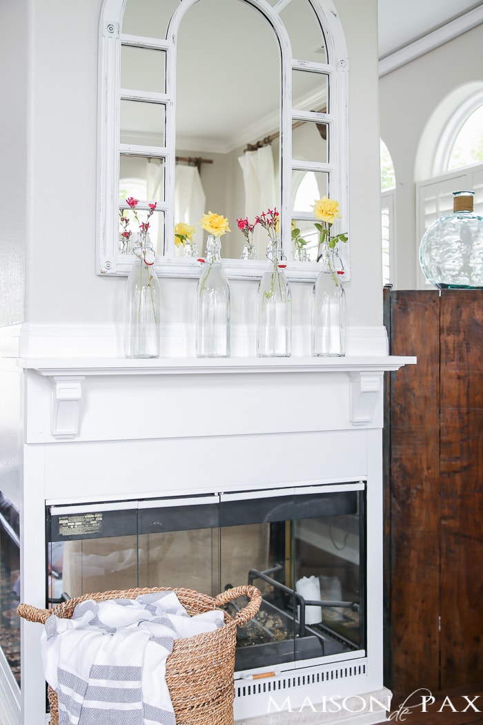 simple glass bottles with clipped flowers on the mantel | quick summer decorating ideas