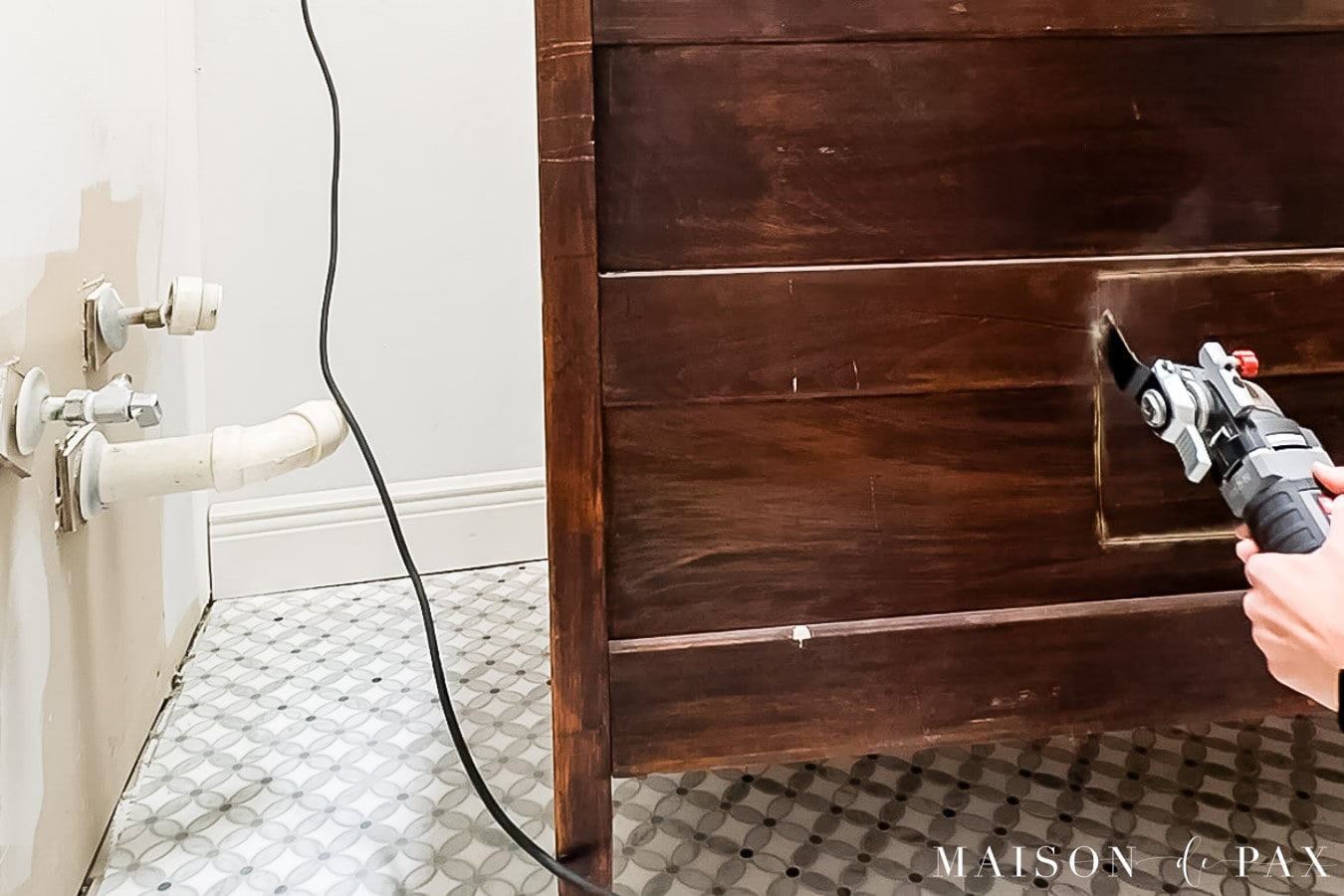 use oscillating saw to cut out back of dresser for plumbing lines