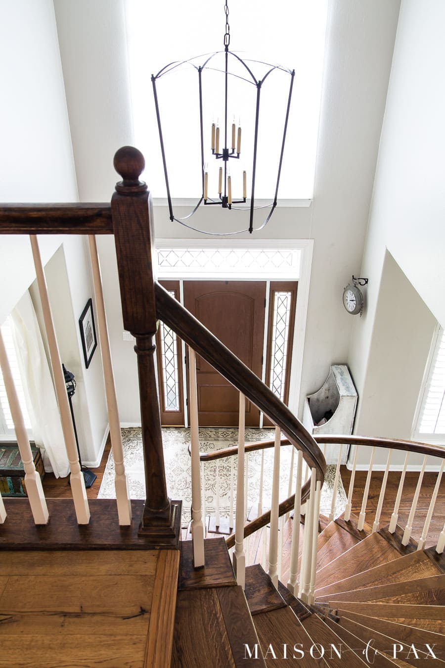 two story entryway with large black lantern chandelier and vintage rug | Maison de Pax