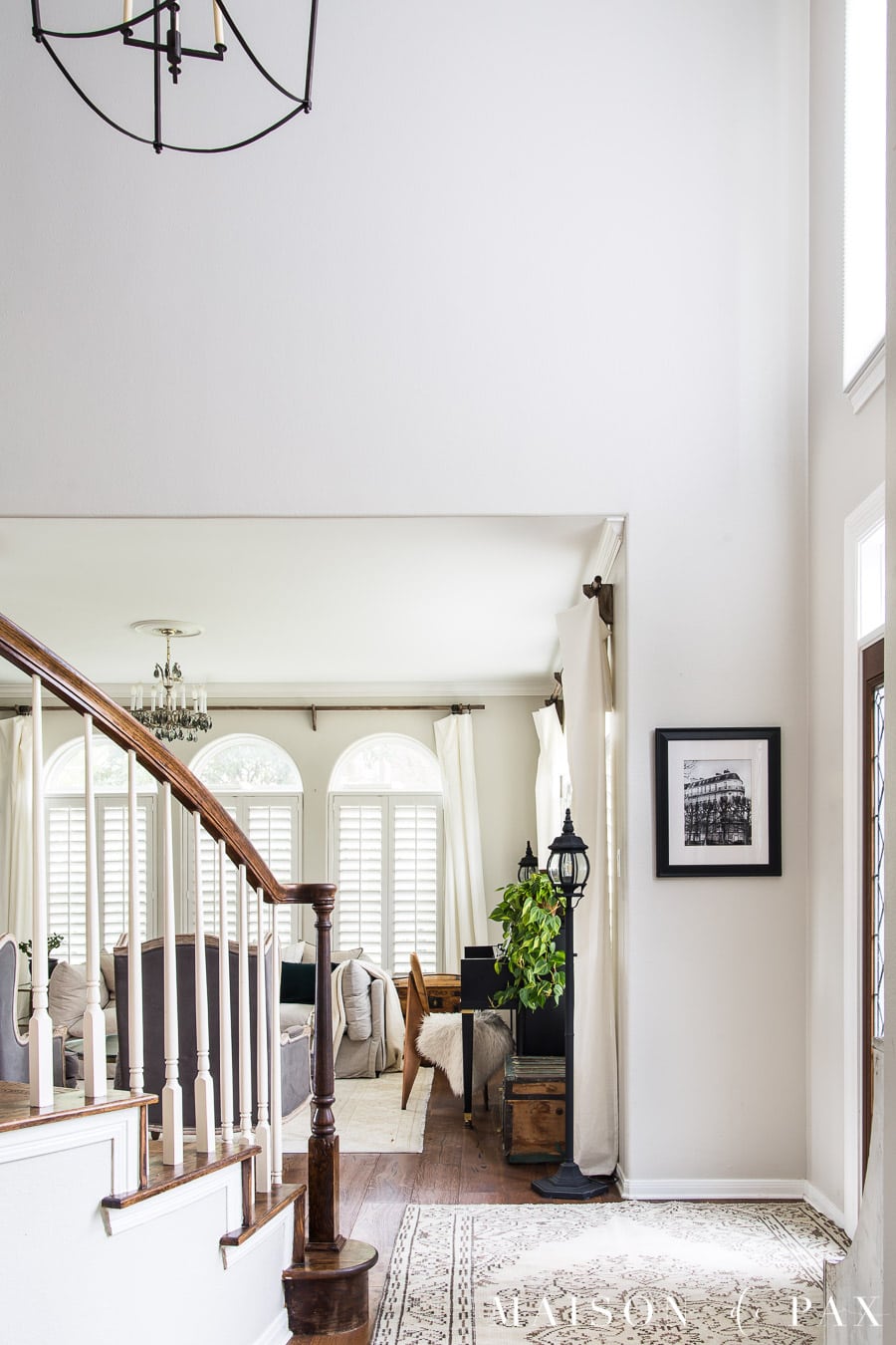 two story entryway and stairwell with large black lantern and vintage rug | Maison de Pax