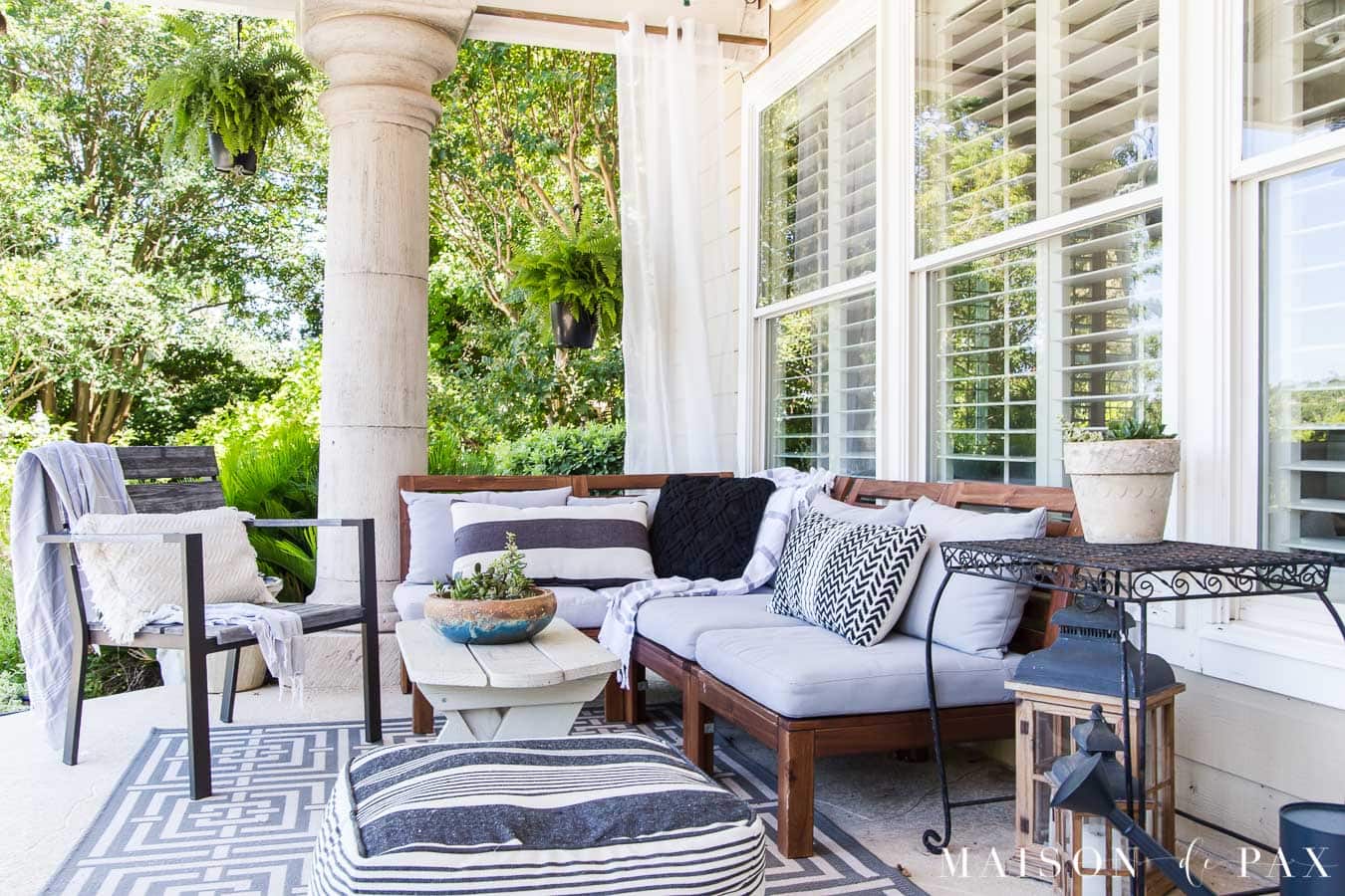covered patio with large columns and wood furniture with cushions | Maison de Pax