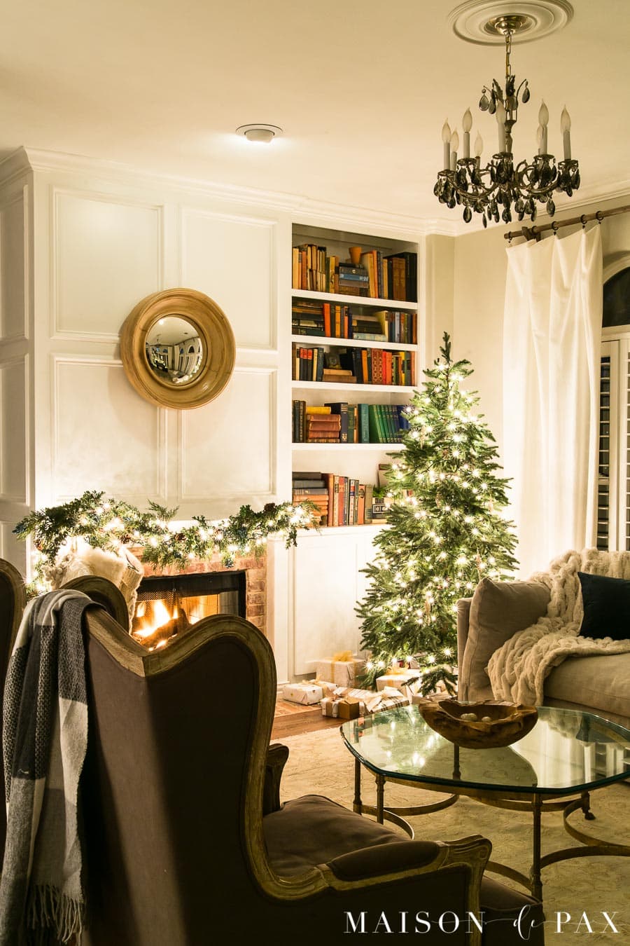 blazing fire, twinkle lights, and christmas tree in living room | Maison de Pax