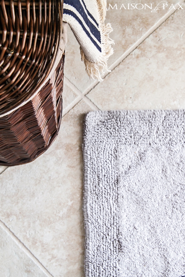 Close-up view of neutral tile bathroom floor and organic bath mat- Maison de Pax