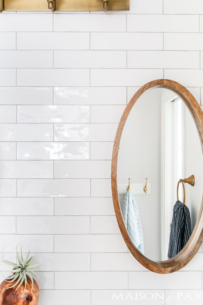 wood mirror against glossy white tile