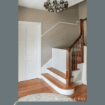 colonial home stairway with custom baby gate and text overlay "classy diy baby gate"