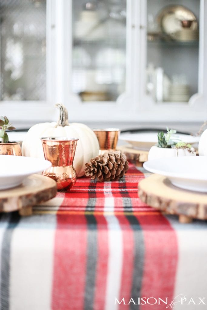 Be inspired to create a gorgeous, rustic Thanksgiving tablescape with these Thanksgiving decorating ideas! This table incorporates plaid, copper, and wood to create a beautiful yet relaxed look.