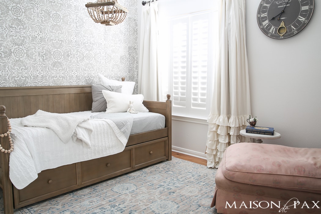 Elegant, neutral little girl room with wood tones and a stenciled accent wall: A gray-washed trundle bed provides the perfect anchor for a gorgeous, neutral yet feminine little girl's room.
