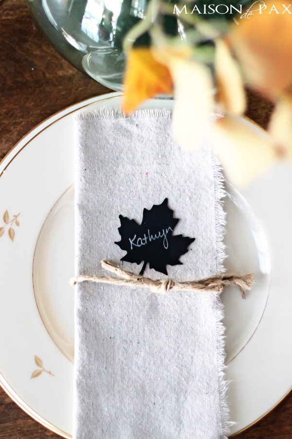 Lovely, simple Thanksgiving tablescape: a grand table and a side table with fall foliage centerpieces, simple neutral china settings, and a few pumpkins | aiweb9ygdry.cmersite.com