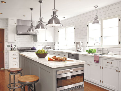 industrial white kitchen with gray island and white subway tile that goes to the ceiling