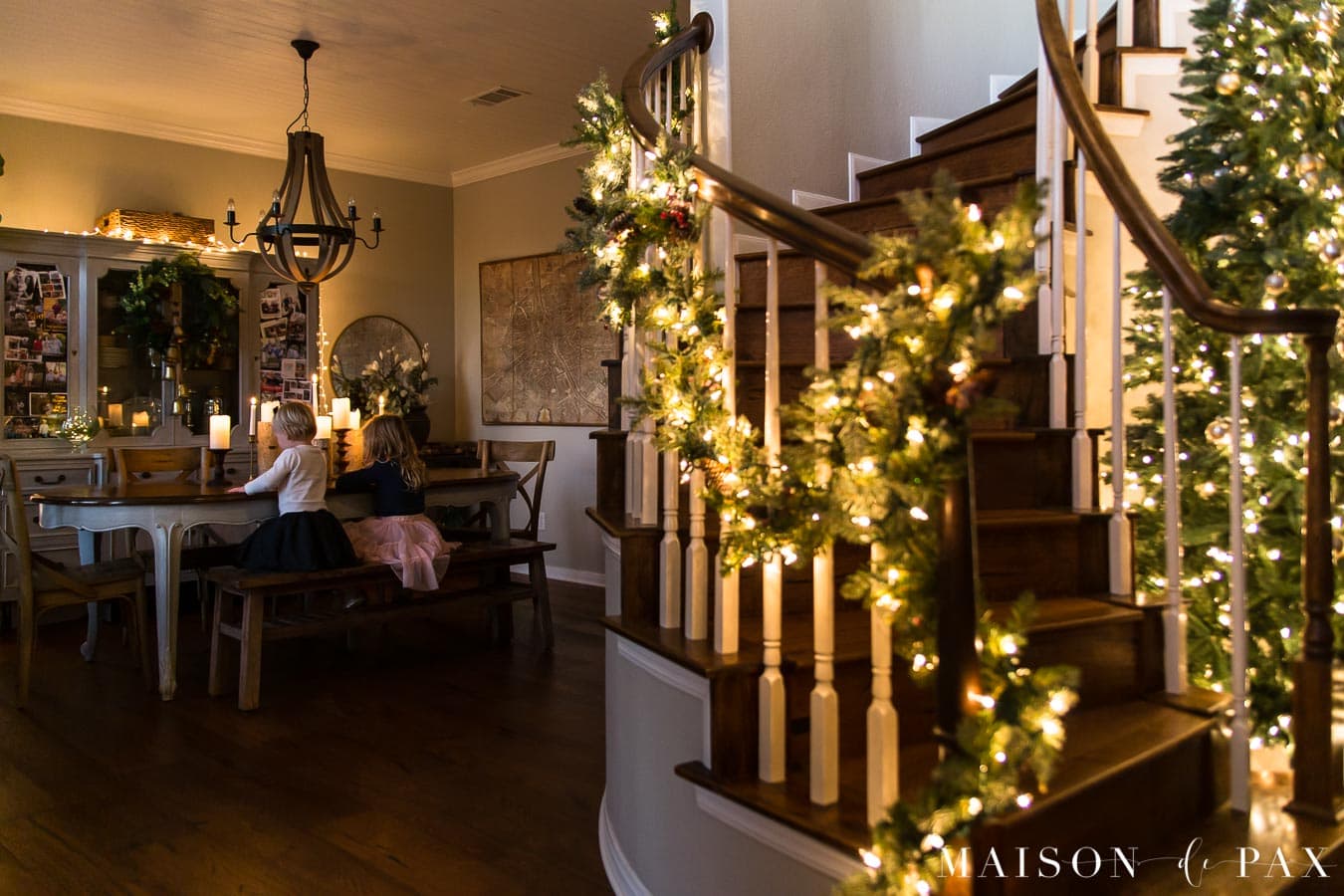 curved stairwell with lit garland by dining room | Maison de Pax 
