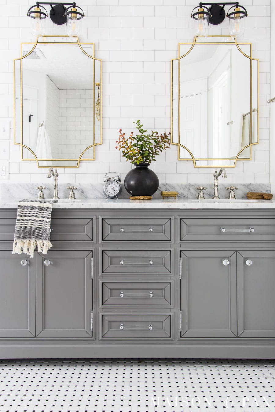 gray vanity with black and white basketweave tile floor