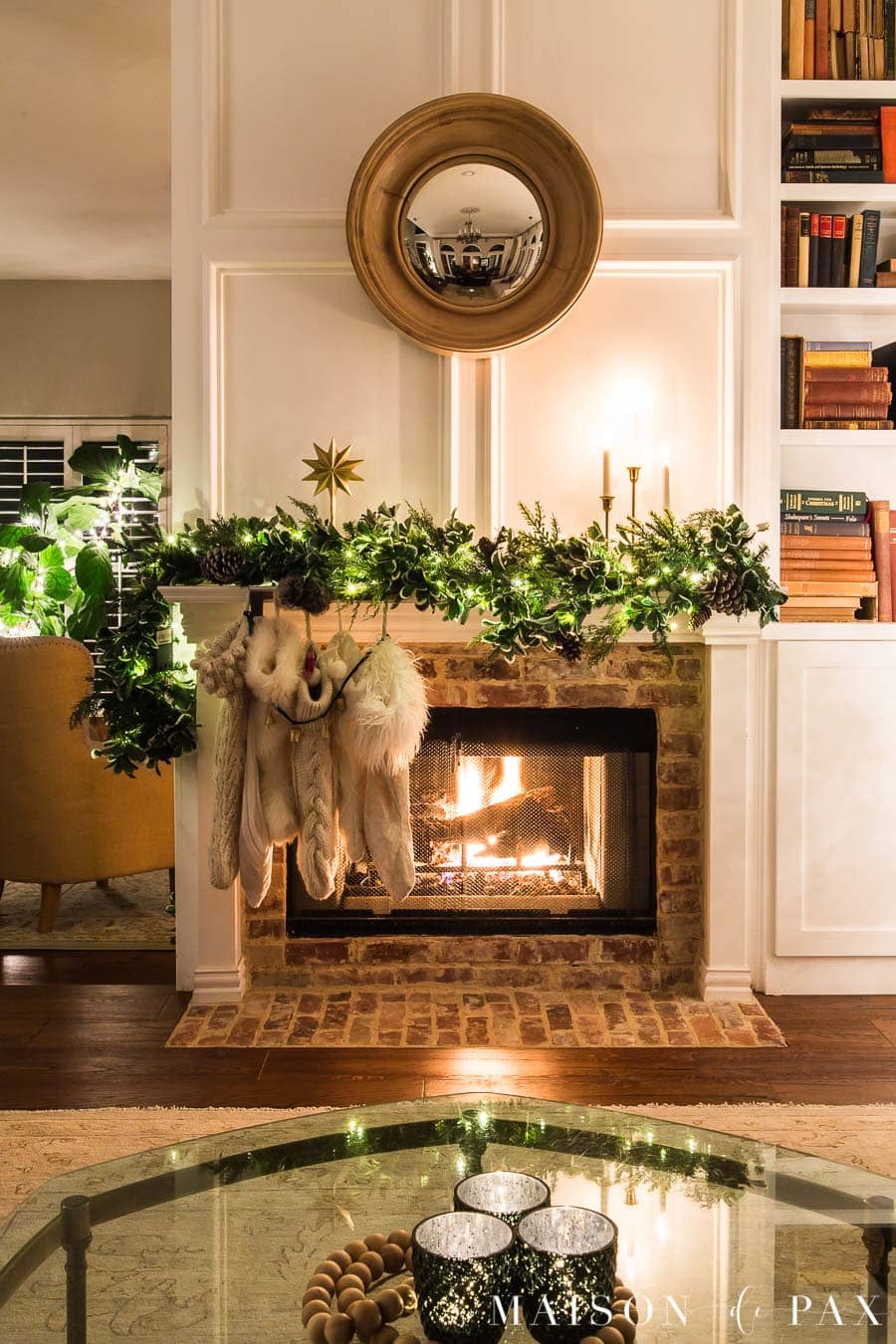 fireplace with asymmetrical garland, off white stockings, gold candles | Maison de Pax