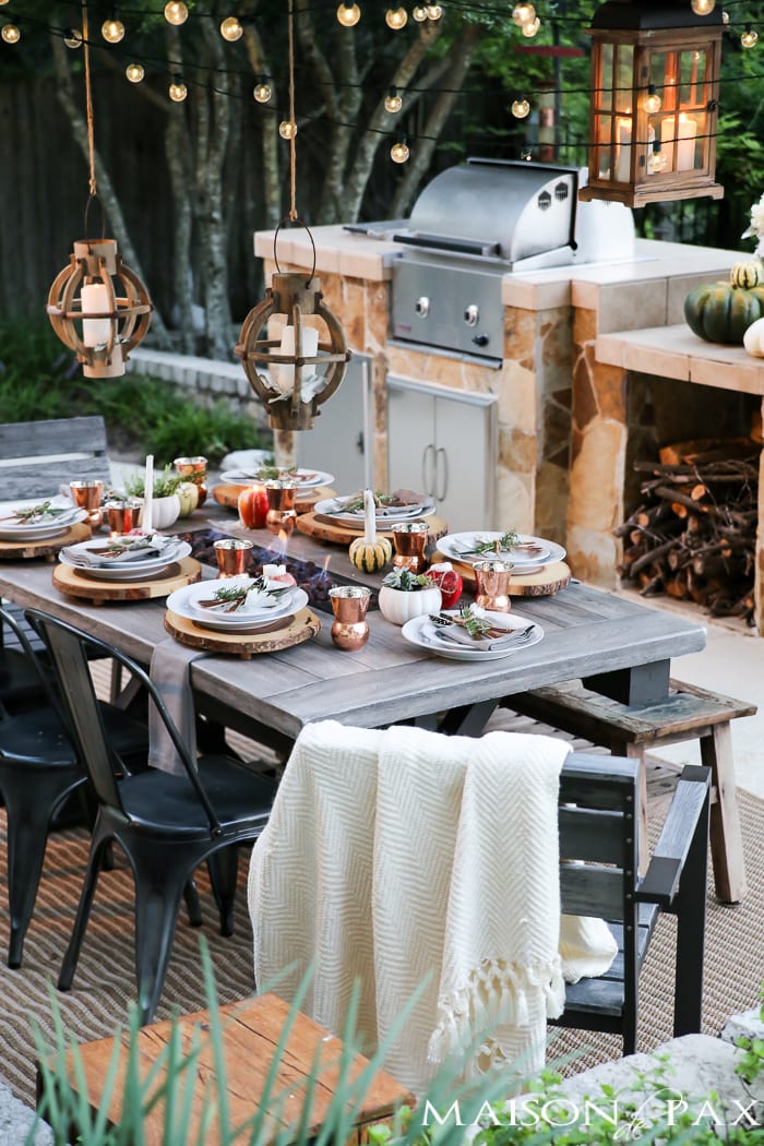 outdoor fall tablescape: lanterns, string lights, apple candles, and other cozy outdoor fall decorating ideas!