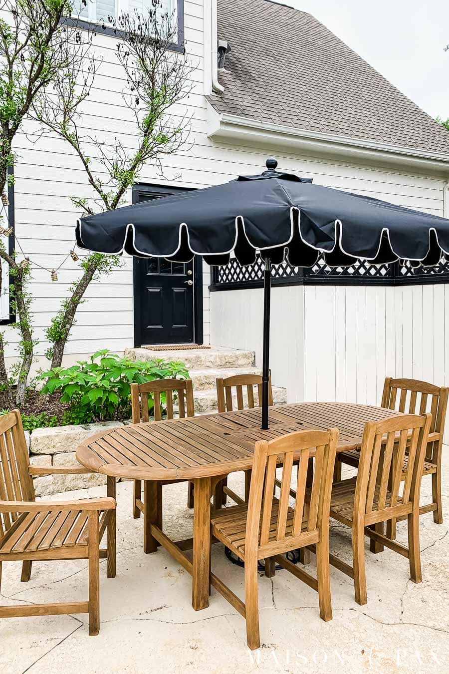 golden teak outdoor dining set with black umbrella