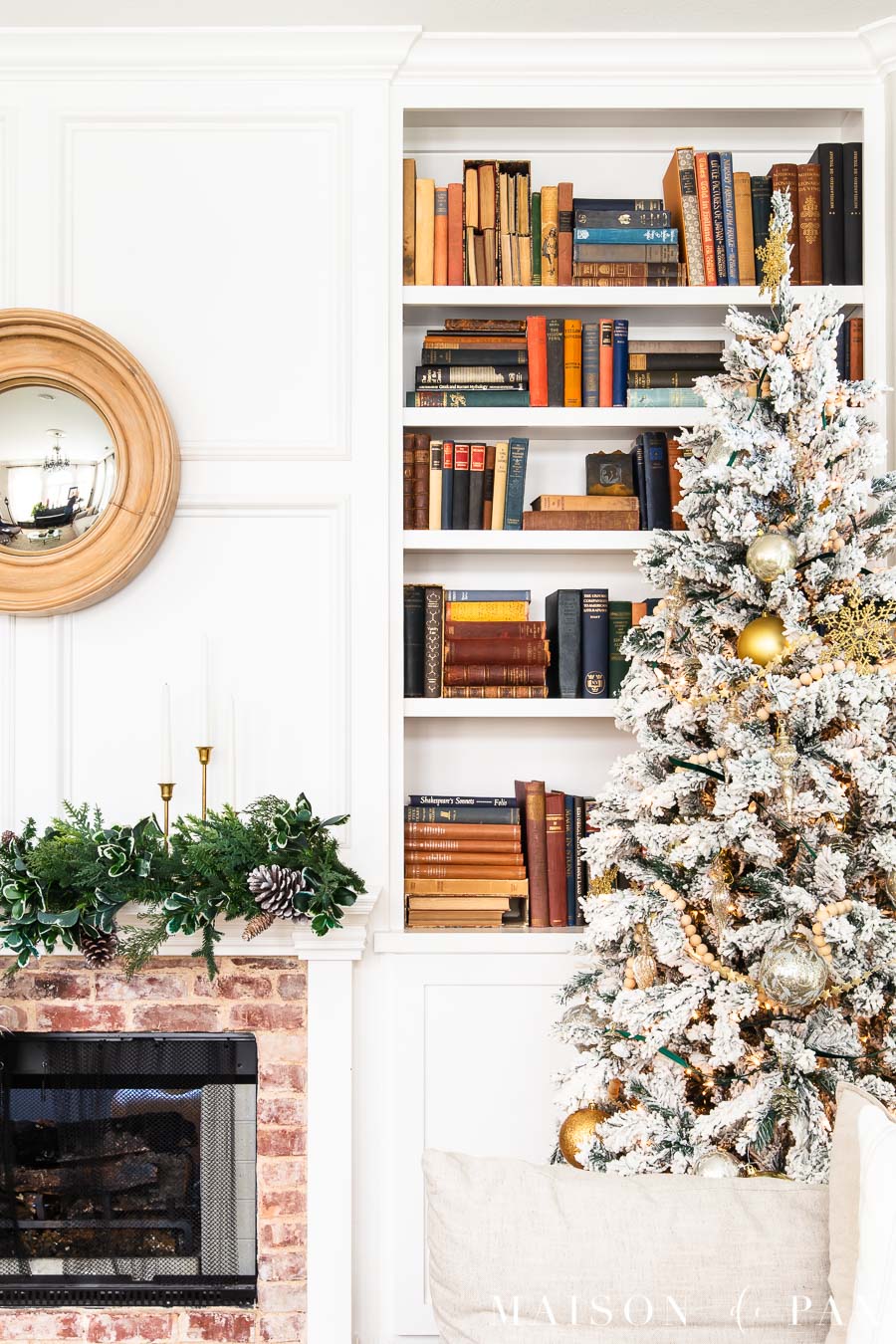 flocked tree with gold ornaments by fireplace | Maison de Pax