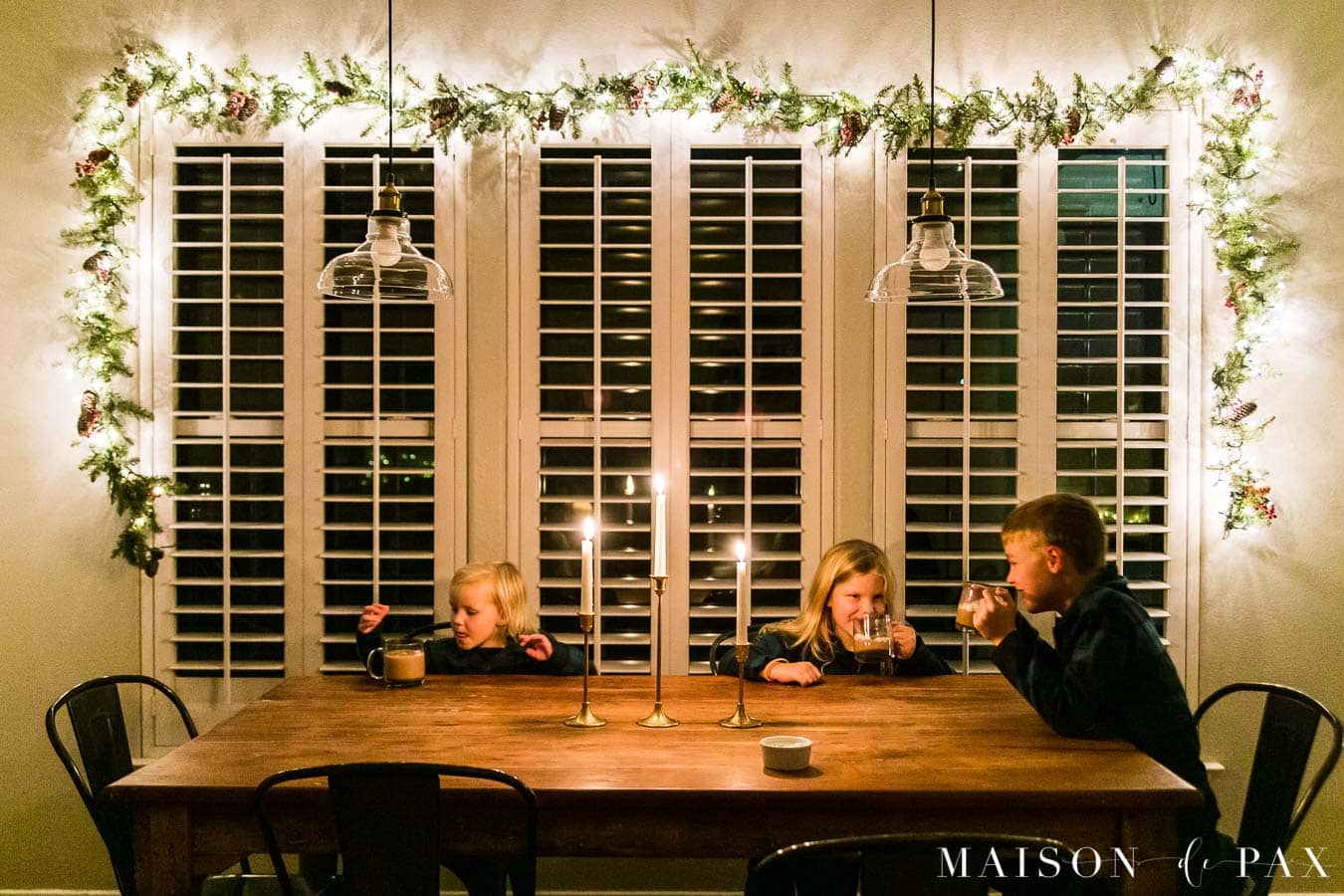 kids enjoying hot chocolate at the table by candlelight | Maison de Pax